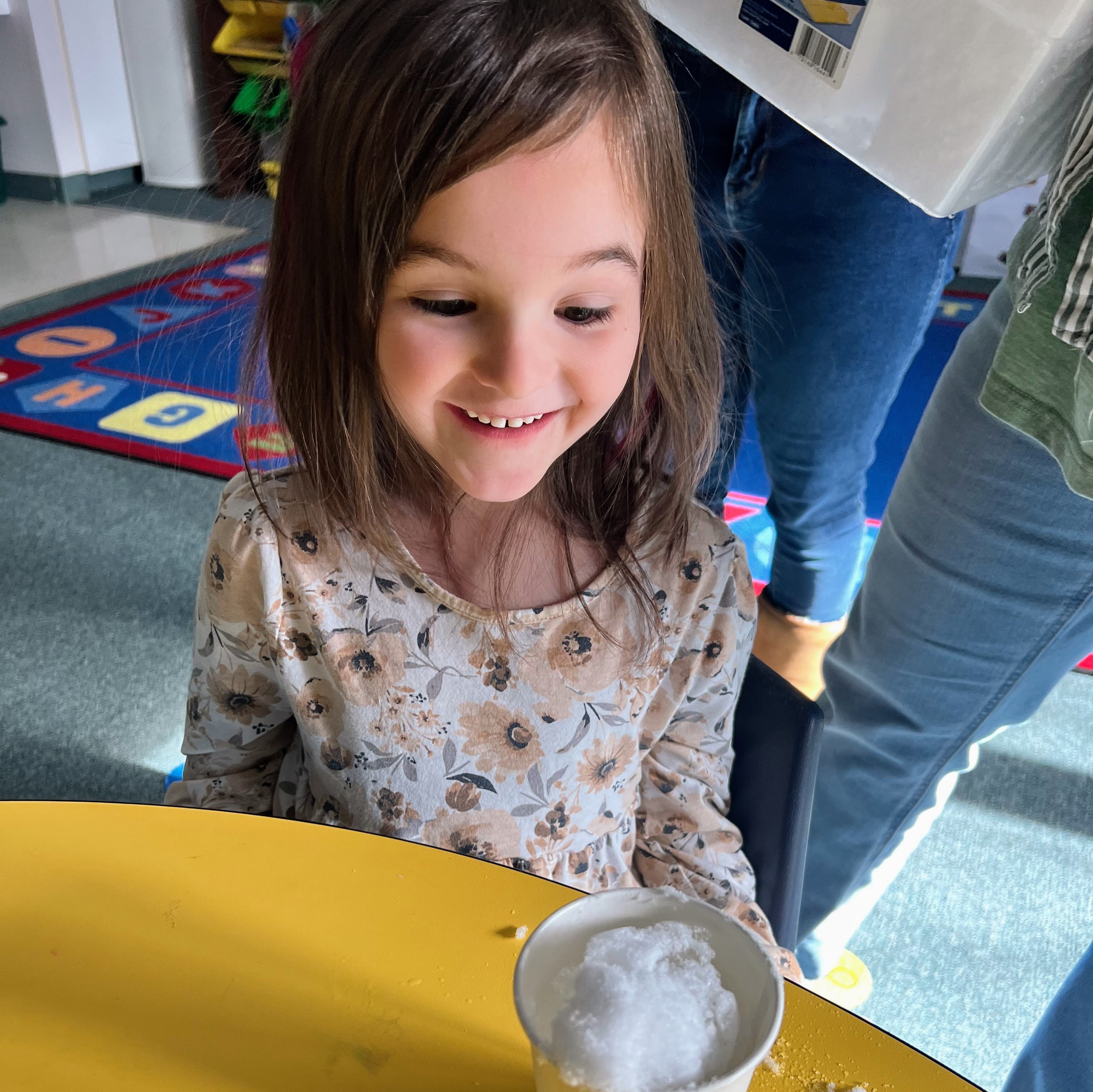 A student completes an experiment with snow floating on water.